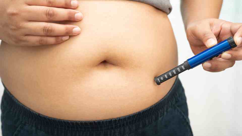 Weight loss pen being injected into stomach